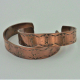 two examples of 1/2 inch wide petroglyph copper cuffs