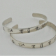 two examples of sterling silver Ohio Petroglyph cuff bracelets