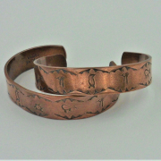 two examples of 1/2 inch wide petroglyph copper cuffs